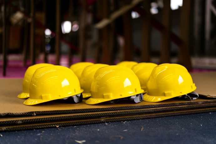 Several bright yellow hard hats are neatly lined up.